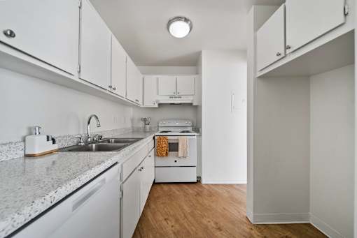 A kitchen with white cabinets and a granite countertop.