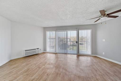 A room with a sliding glass door and a ceiling fan.