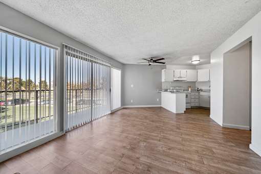 A spacious room with a sliding glass door and a ceiling fan.