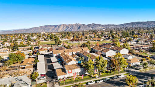 A residential area with houses and cars under a clear sky.