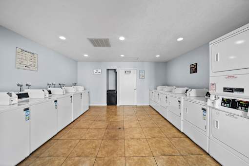 A laundromat with a row of washers and dryers.