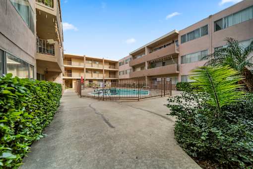 A courtyard with a pool surrounded by buildings and greenery.