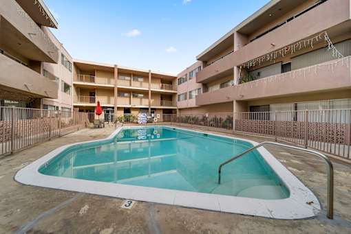 A small pool in a courtyard surrounded by buildings.