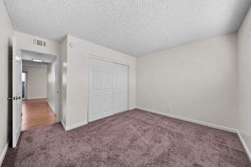 A room with a carpeted floor and a white door.