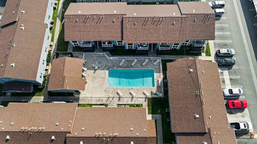 An aerial view of a building with a pool in the middle.
