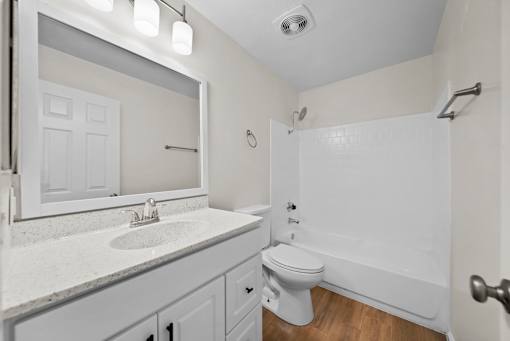 A white bathroom with a toilet, sink, and bathtub.