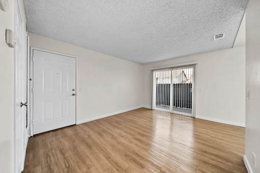 A room with a white door and a window with bars.