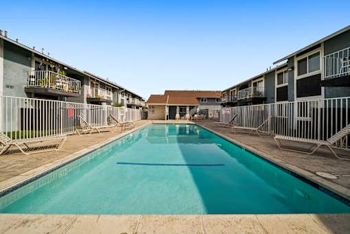 A long rectangular pool in the middle of a courtyard surrounded by buildings.