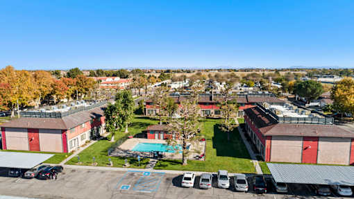 A parking lot with cars and a pool in the middle of a residential area.