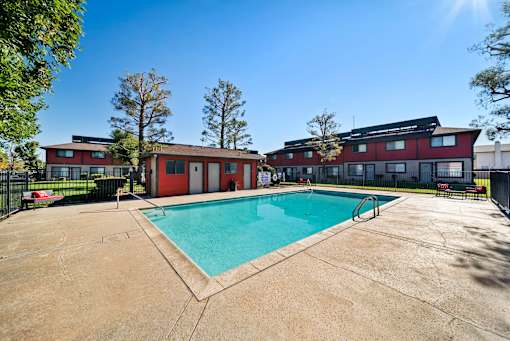 A swimming pool in front of a red building.
