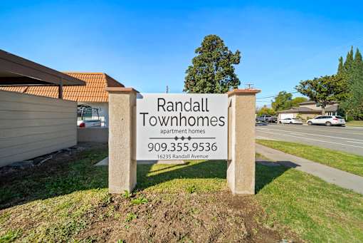 A sign for Randall Townhomes stands in front of a building.