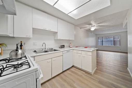 A white kitchen with a stove and sink.