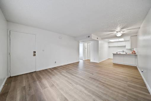 A room with a white door and a wooden floor.