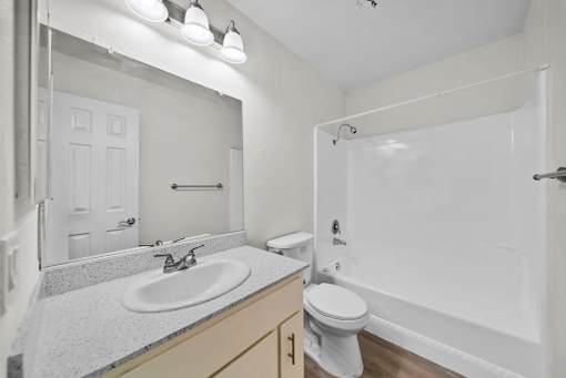 A white bathroom with a sink, toilet, and bathtub.