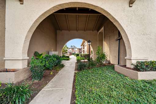 A pathway leads through a tunnel of arches.