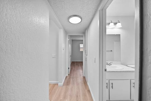 A long hallway with a bathroom at the end.