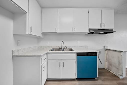 A kitchen with white cabinets and a blue dishwasher.