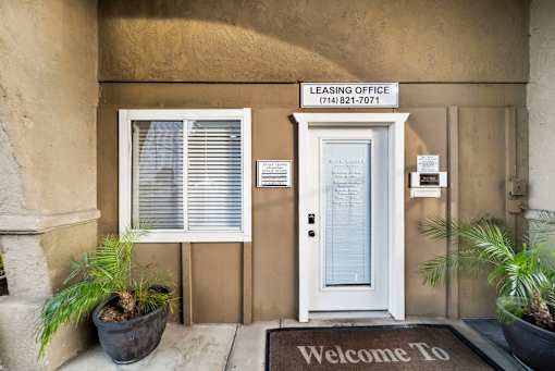 A leasing office with a welcome mat and a door.