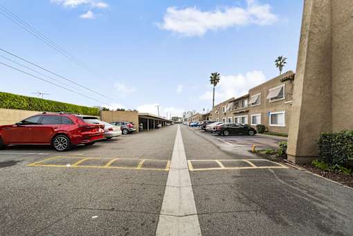 A red car is parked on the left side of a street.