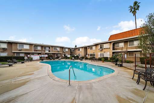 A swimming pool in a courtyard surrounded by apartment buildings.