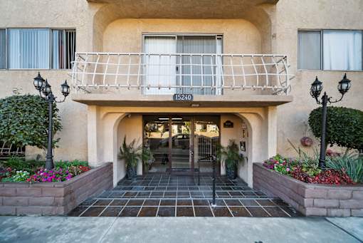 The front of a building with a balcony and a doorway.