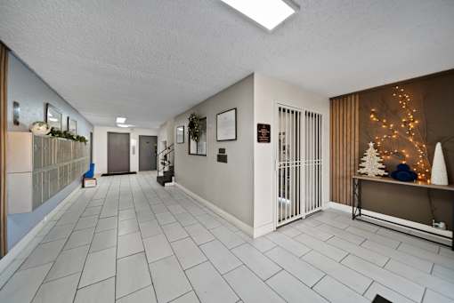 A long hallway with a Christmas tree in the corner.