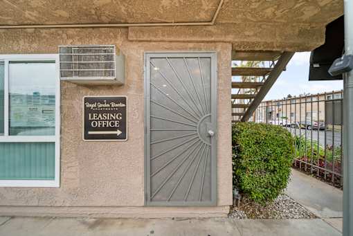 A leasing office sign is on the wall of a building.