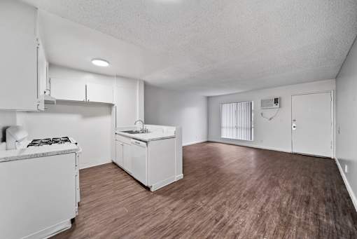 A kitchen with white appliances and wooden floors.