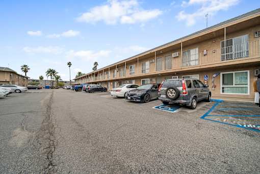 A parking lot with cars and apartment buildings in the background.