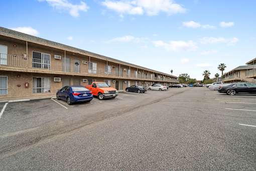 A parking lot with cars and apartment buildings in the background.