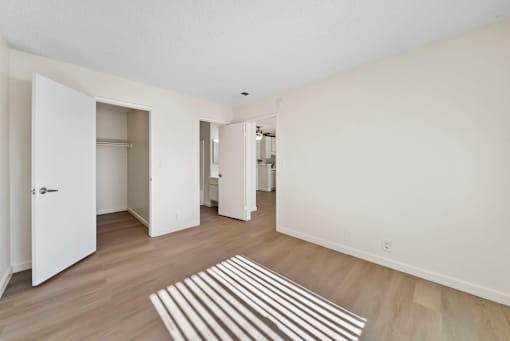 A room with a striped rug on the floor and a white door.