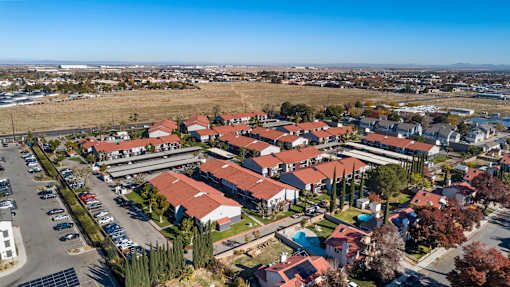 A bird's eye view of a residential area with houses and parked cars.