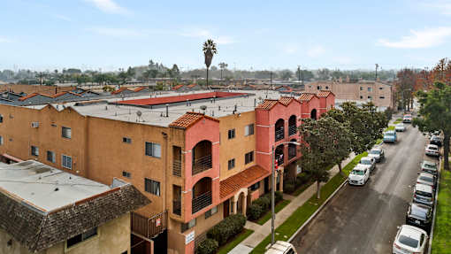 A street view of a residential area with cars parked on the side of the road.