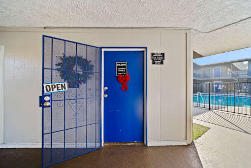 A blue door with a sign that says "OPEN" on it.