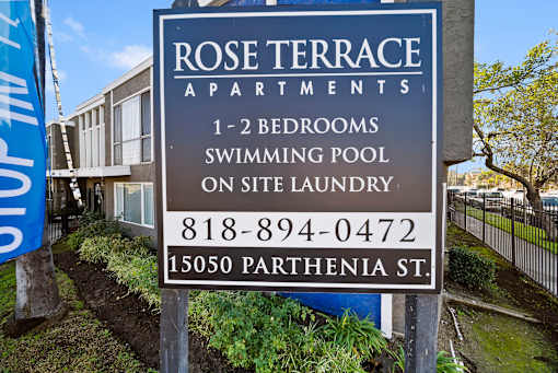 A sign for Rose Terrace Apartments with a swimming pool on site.