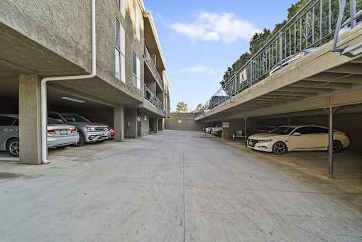 A parking garage with cars parked on both sides.