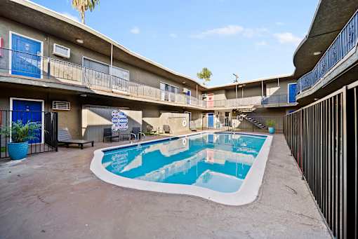 A small pool in a courtyard surrounded by buildings.