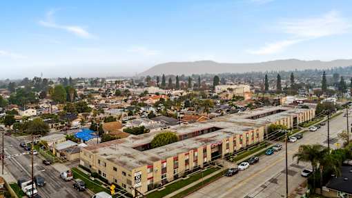 A cityscape with buildings, cars, and a mountain in the distance.