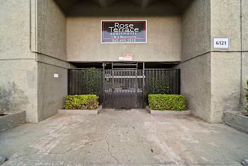 A sign for Rose Terrace is on the wall above a gate.