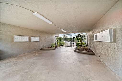 A concrete room with a planter and two white boards on the wall.