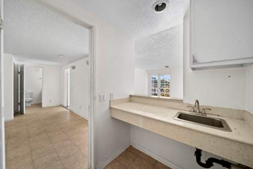 A bathroom with a sink and a mirror.