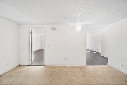 A room with a white wall and a wooden floor.