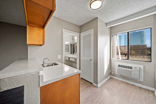 A kitchen with a white counter top and wooden cabinets.