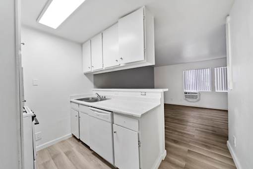 A kitchen with white cabinets and a white counter top.