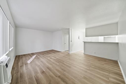 A room with wooden flooring and white walls.
