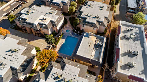 A bird's eye view of a residential area with a swimming pool.