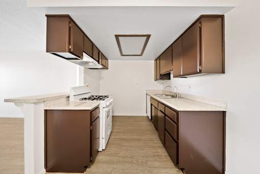 A kitchen with brown cabinets and a white counter.
