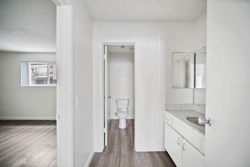 A white bathroom with a toilet, sink, and mirror.