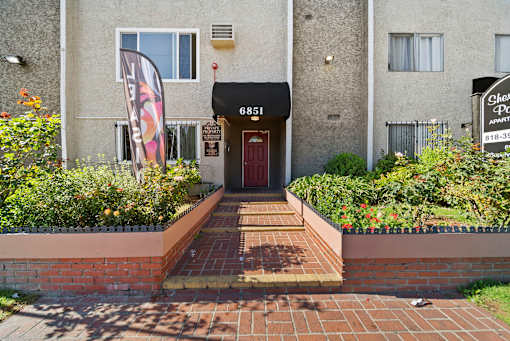 The front of a building with a red door and a sign that says "6851".