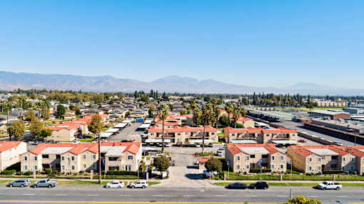 A residential area with houses and cars under a clear sky.